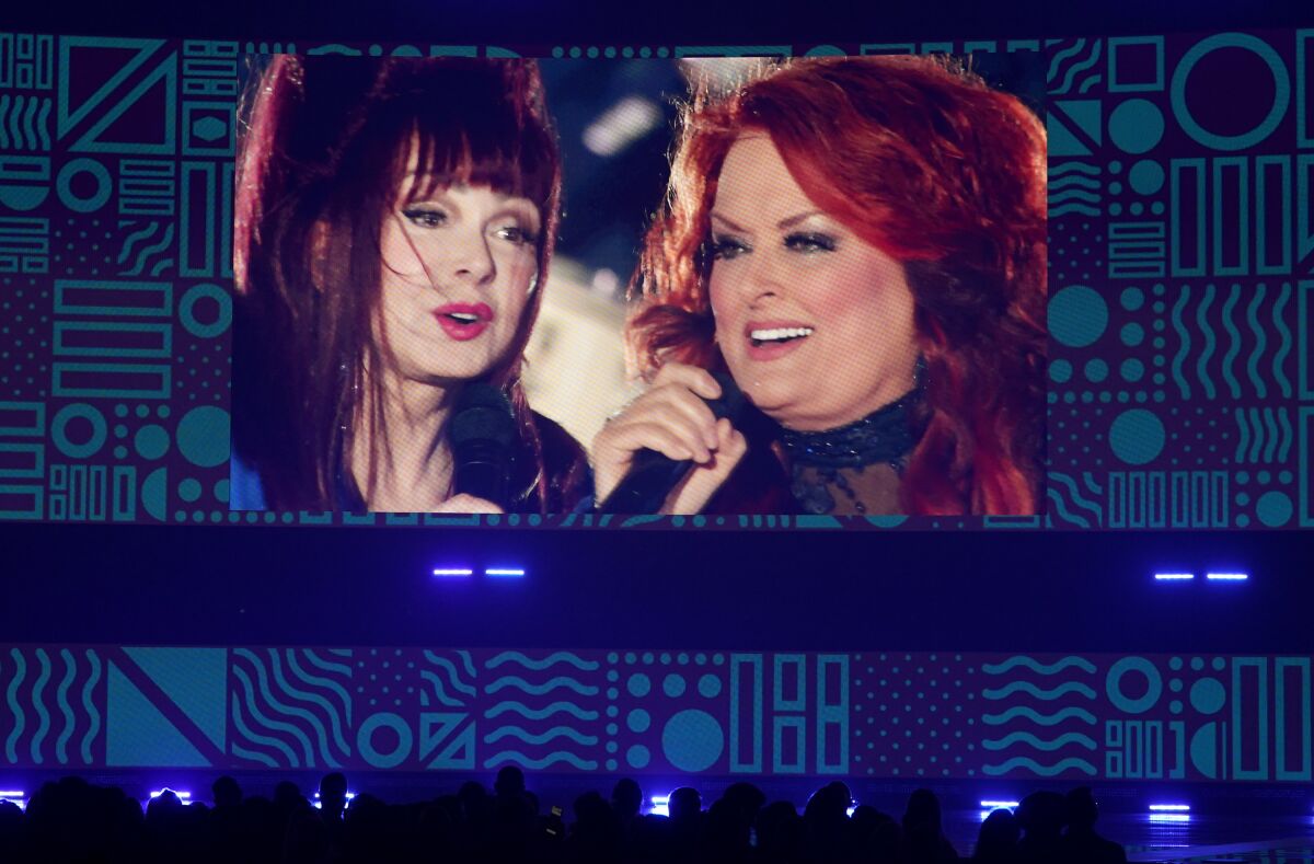 A screen projecting two women singing together