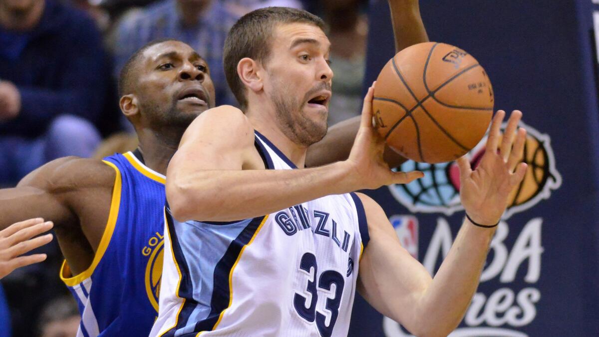 Memphis Grizzlies center Marc Gasol, right, looks to pass in front of Golden State Warriors center Festus Ezeli during the Grizzlies' 105-98 win Tuesday.