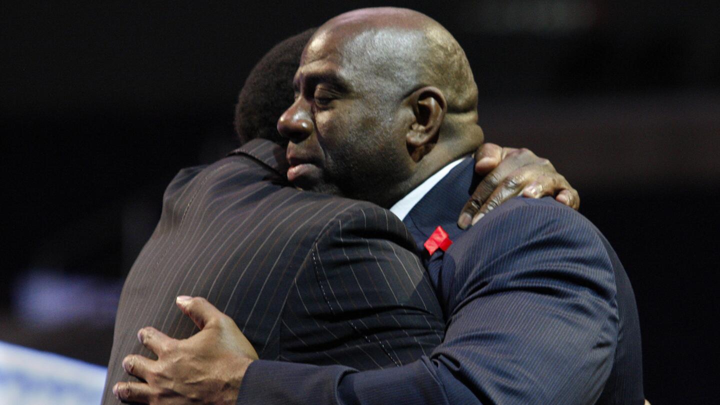 Magic Johnson is hugged by former Lakers teammate A.C. Green during a news conference at Staples Center in November 2011 to commemorate the 20th anniversary of Johnson's announcement that he had HIV.