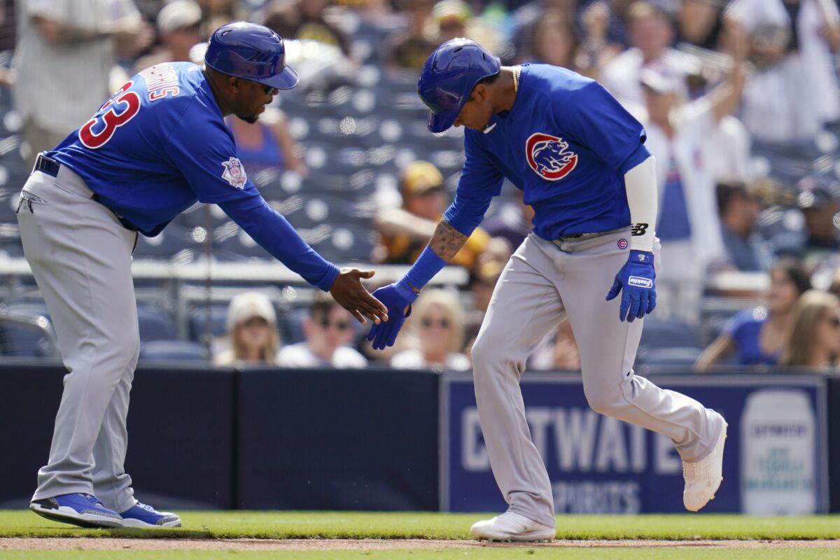 Chicago Cubs' Sergio Alcantara, right, is congratulated by third base coach Willie Harris after hitting a home run during the eighth inning of the team's baseball game against the San Diego Padres, Wednesday, June 9, 2021, in San Diego. (AP Photo/Gregory Bull)