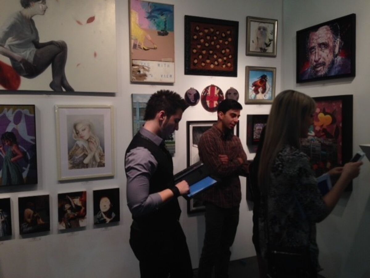 Young collectors peruse the Thinkspace Gallery booth at the LA Art Show.