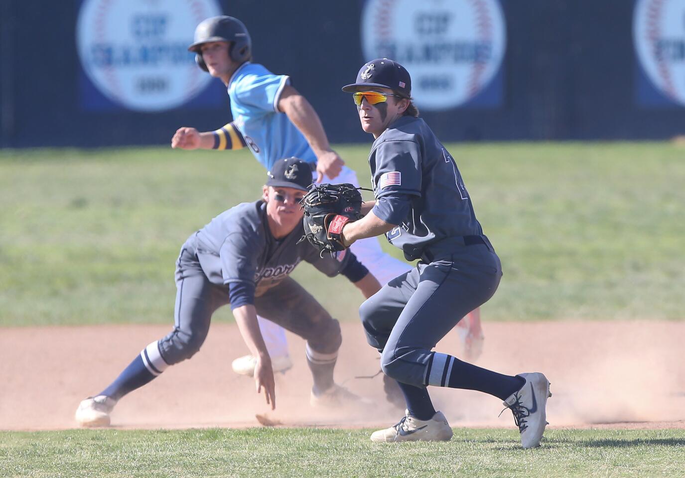 Newport Harbor first baseman Braham Duncan, right, scoops up an infield hit and throws to home to get the out in a Wave League game at Marina on Tuesday.