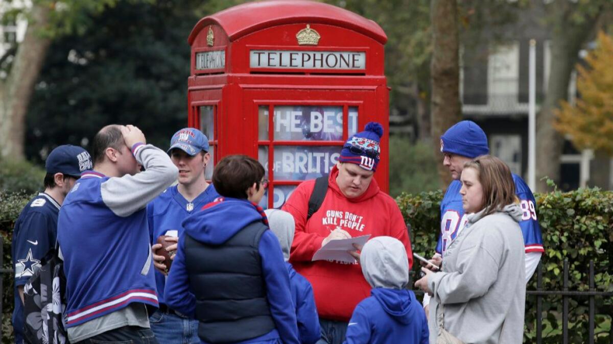 New York Giants fans wait outside before an NFL fan rally Saturday at the NFL House in Victoria House in London.