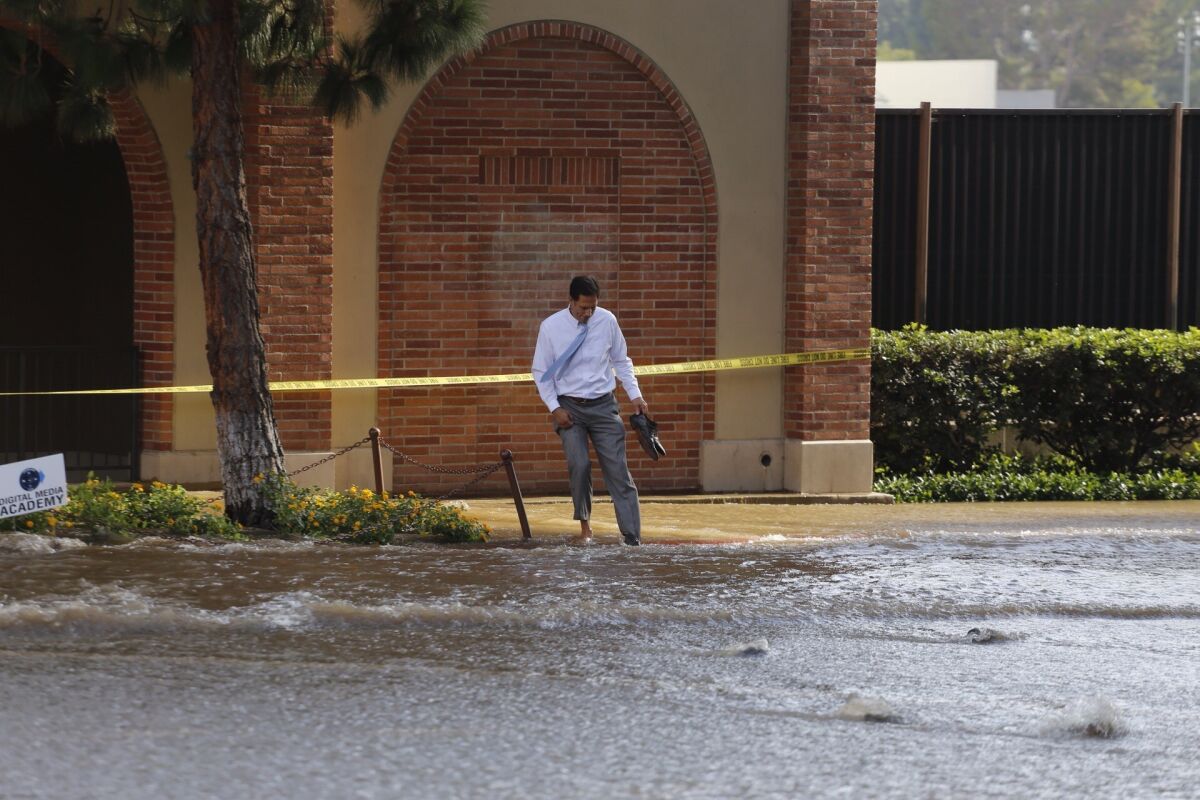Jerry Markham, wades into a flooded walkway in 2014 after a water main break on Sunset Boulevard near the UCLA campus.