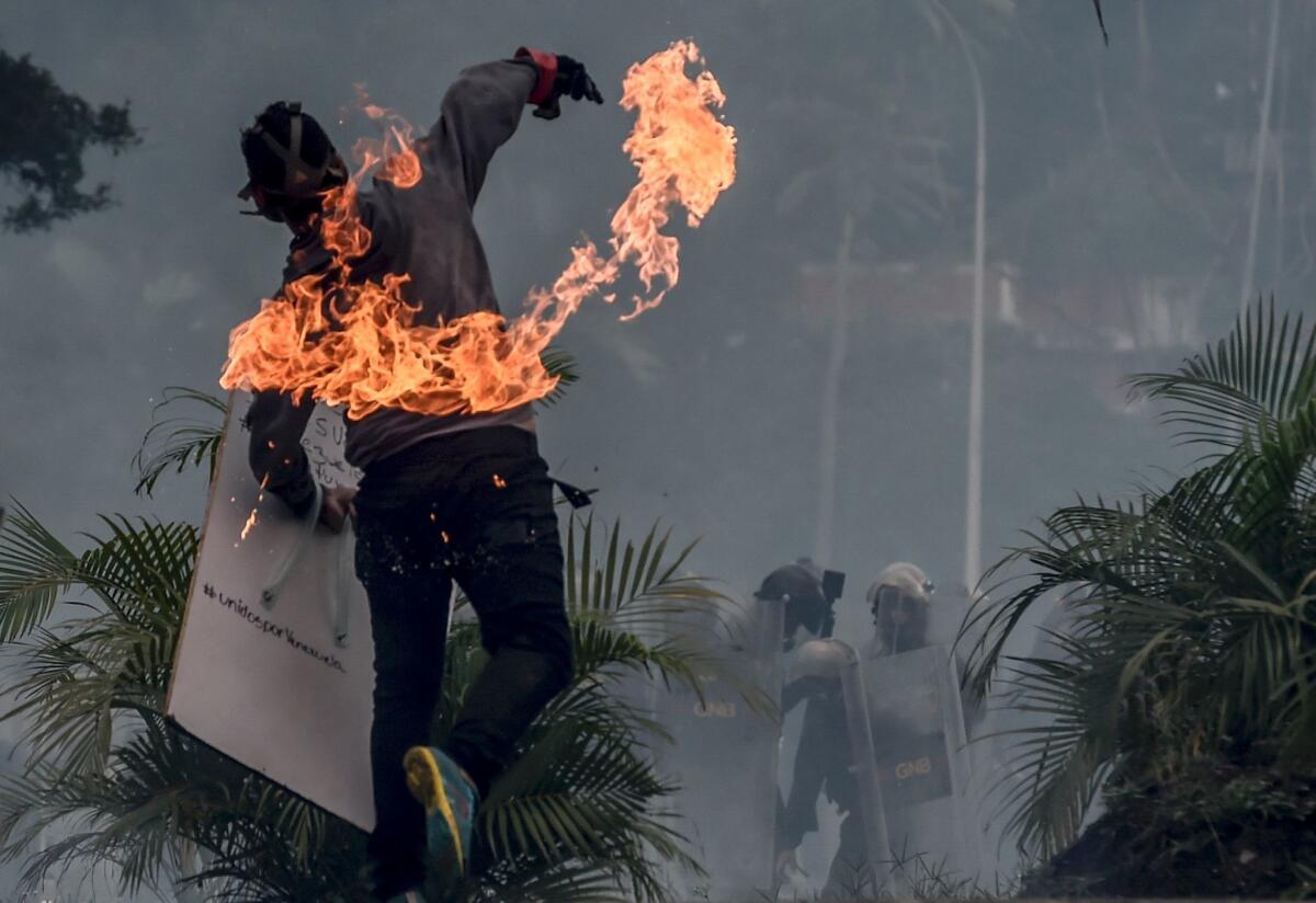 An opposition activist clashes with riot police during a demonstration against the government of Venezuelan President Nicolas Maduro in Caracas on Monday.
