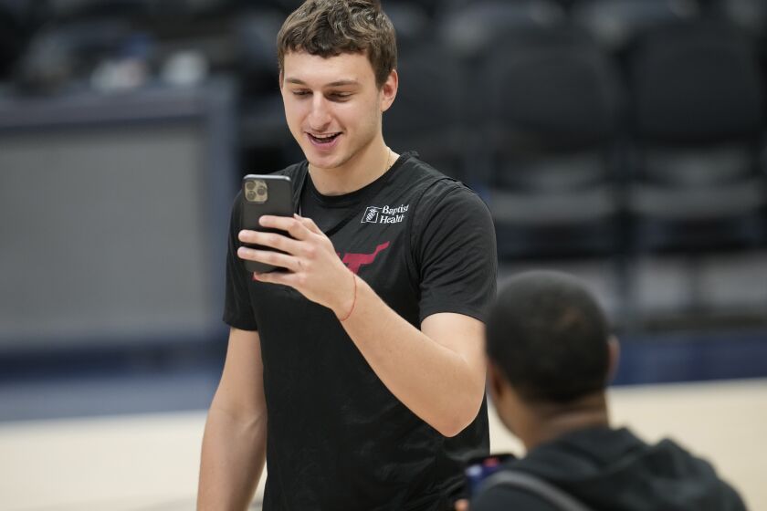 Miami Heat forward Nikola Jovic does an interview on a mobile telephone before NBA basketball practice, Wednesday, May 31, 2023, in Denver. The Heat face the Denver Nuggets in Game 1 of the NBA Finals Thursday. (AP Photo/David Zalubowski)