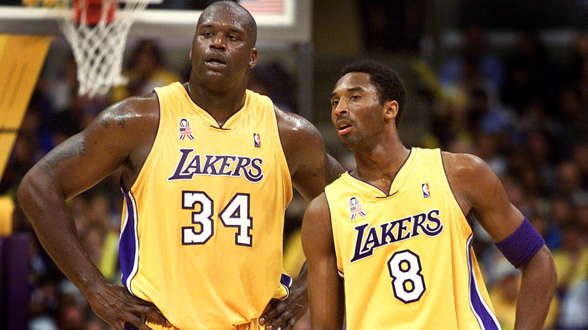 Shaquille O'Neal, left, and teammate Kobe Bryant look on during a game against the Cleveland Cavaliers at Staples Center on March 26, 2002.