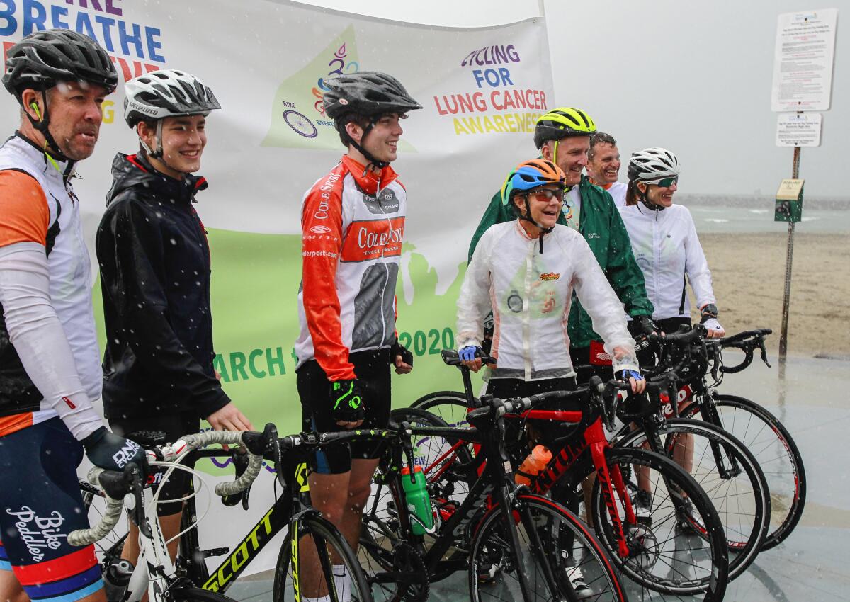 Along with supporters, Isabella de la Houssaye (middle), a stage 4 cancer patient, begins her cross country bike ride in Ocean Beach on March 10, 2020 in San Diego, California. De la Houssaye, 56, is riding cross country to Jacksonville, FL to raise awareness for lung cancer research.