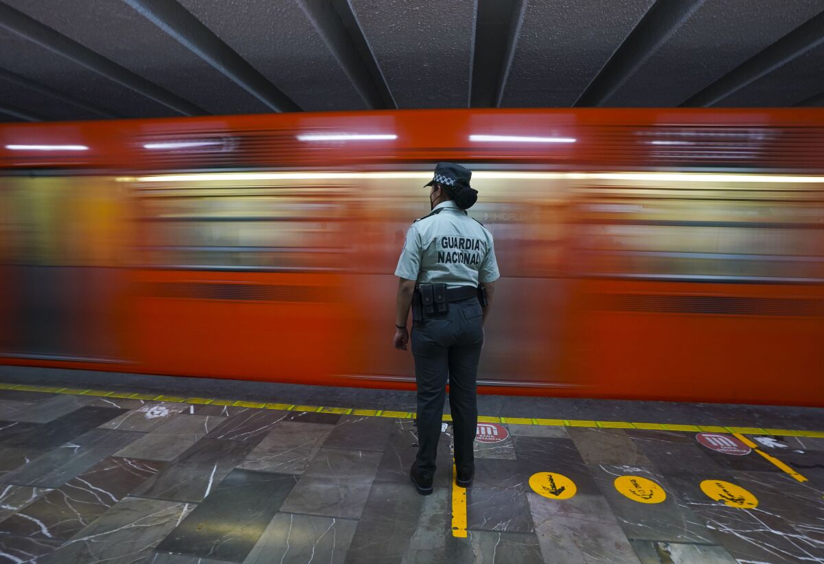 A member of the Mexican National Guard stands guard at a city's subway station in Mexico City, Thursday, Jan. 12, 2023. The mayor of Mexico City says that more the 6 thousand National Guard officers will be posted in the city's subway system after a series of accidents that officials say could be due to sabotage. (AP Photo/Fernando Llano)