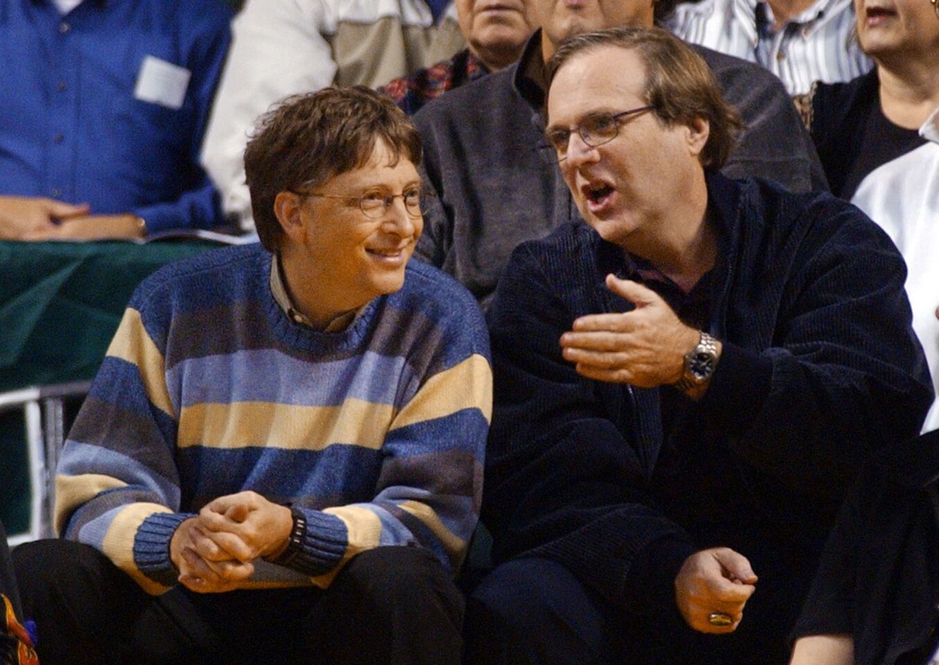 Microsoft Chairman Bill Gates, left, chats with Portland Trail Blazers owner and former business partner Paul Allen during a game between the Trail Blazers and Seattle SuperSonics in Seattle on March 11, 2003.