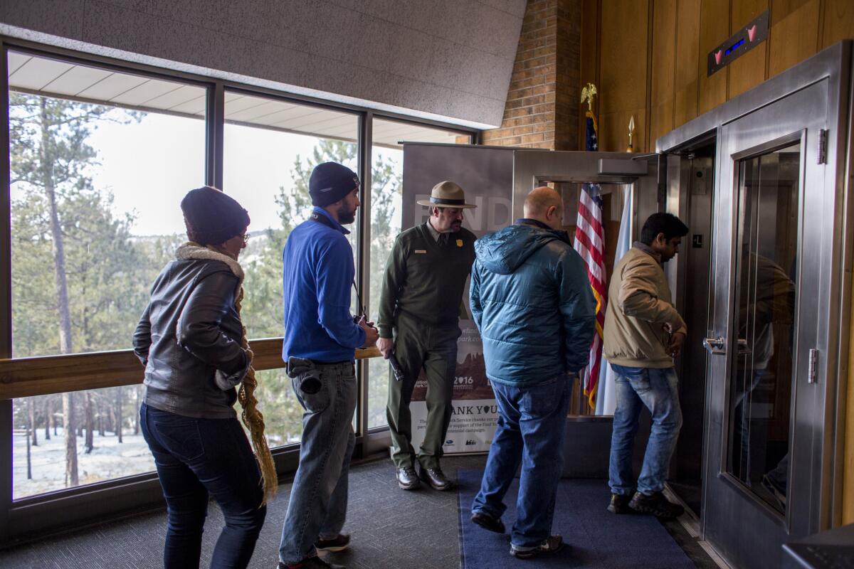 Park ranger and tour guide Brad Yoder, center, escorts a group to the elevators that will bring the tour to the cave. (Kristina Barker / For The Times) More photos