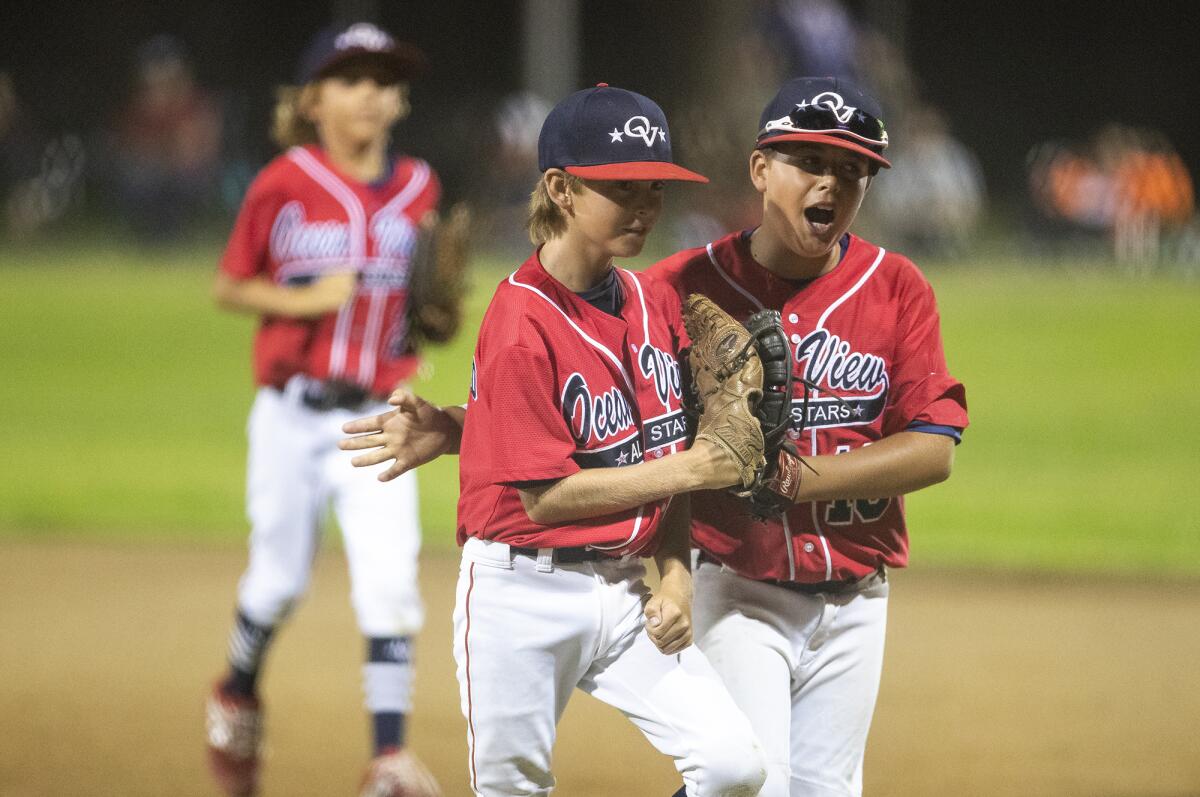 Ocean View Little League's Duncan McLeod, left, celebrates with Luke Frohn after getting out of a tight spot in the fourth inning against Claremont Little League in the Little League Southern California state tournament at Stearns Champions Park in Long Beach on Monday.