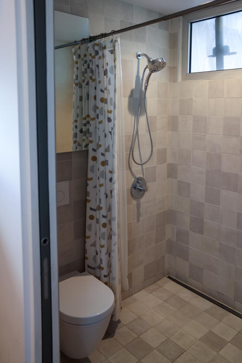 The bathroom is streamlined, similar to a wetroom.