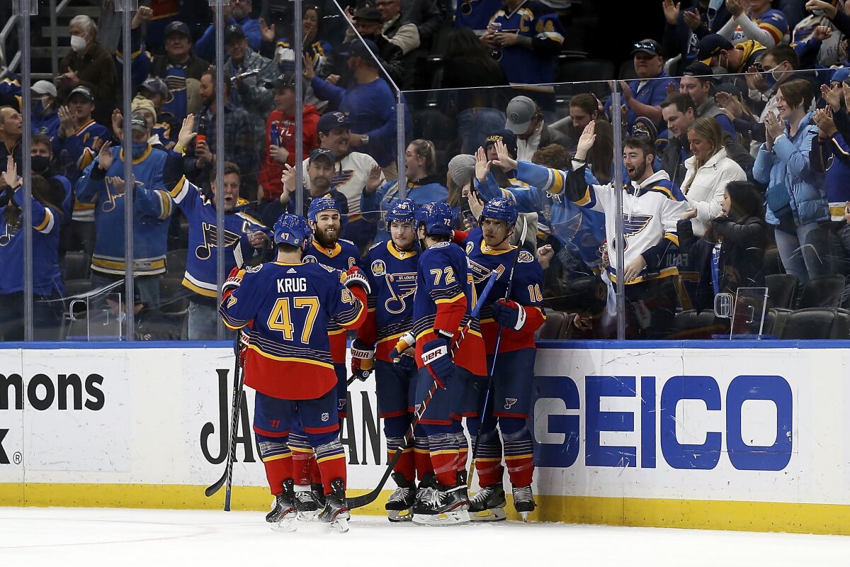 Members of the St. Louis Blues celebrate a goal scored by teammate Brayden Schenn during the third period of an NHL hockey game against the Nashville Predators, Monday, Jan. 17, 2022, in St. Louis. (AP Photo/Scott Kane)