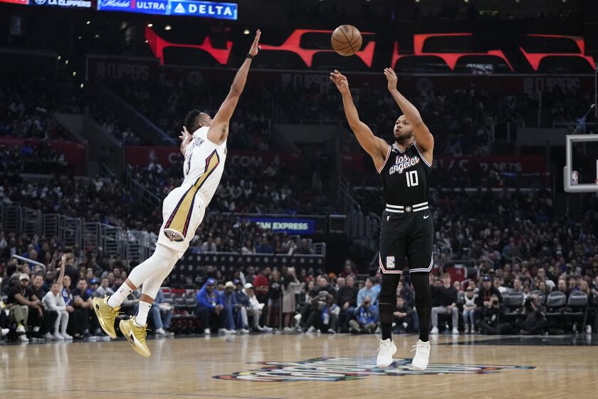 Los Angeles Clippers guard Eric Gordon, right, shoots as New Orleans Pelicans guard CJ McCollum defends during the first half of an NBA basketball game Saturday, March 25, 2023, in Los Angeles. (AP Photo/Mark J. Terrill)