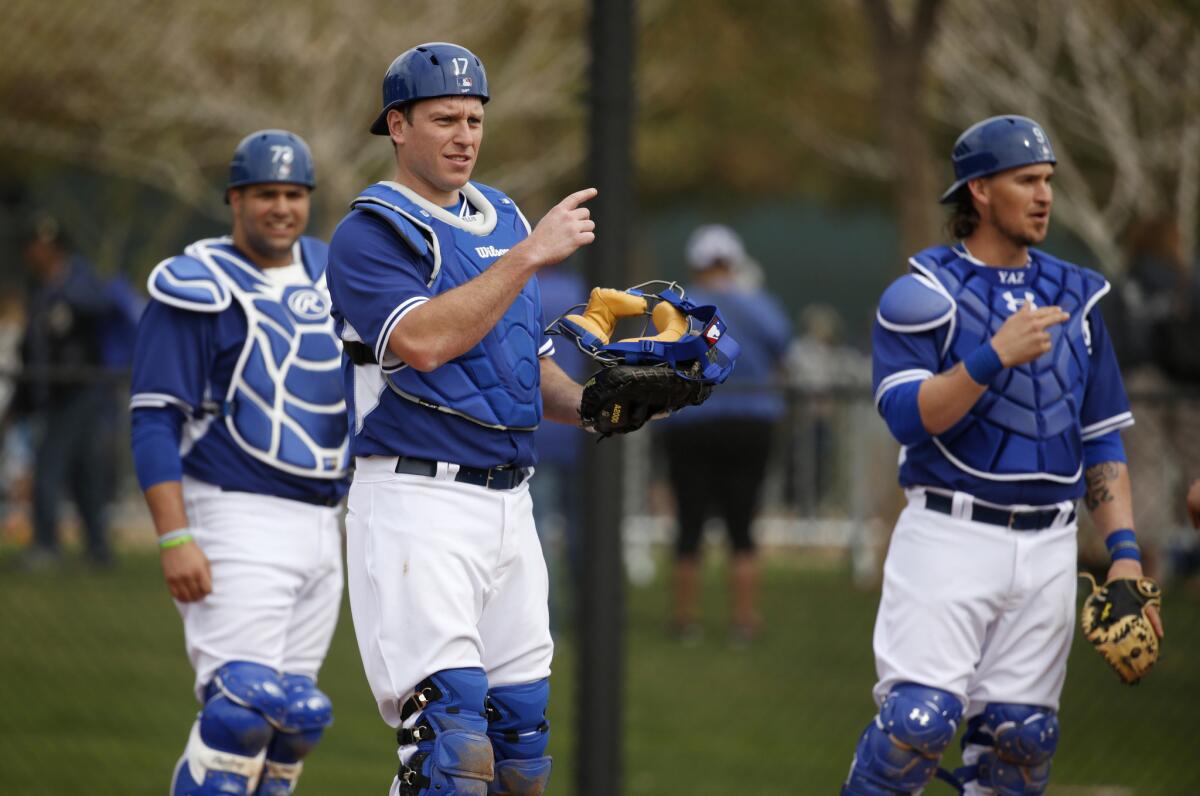 A.J. Ellis, center, goes through drills with Shawn Zarraga, left, and Yasmani Grandal, right, during the Dodgers' pitchers and catchers workout.