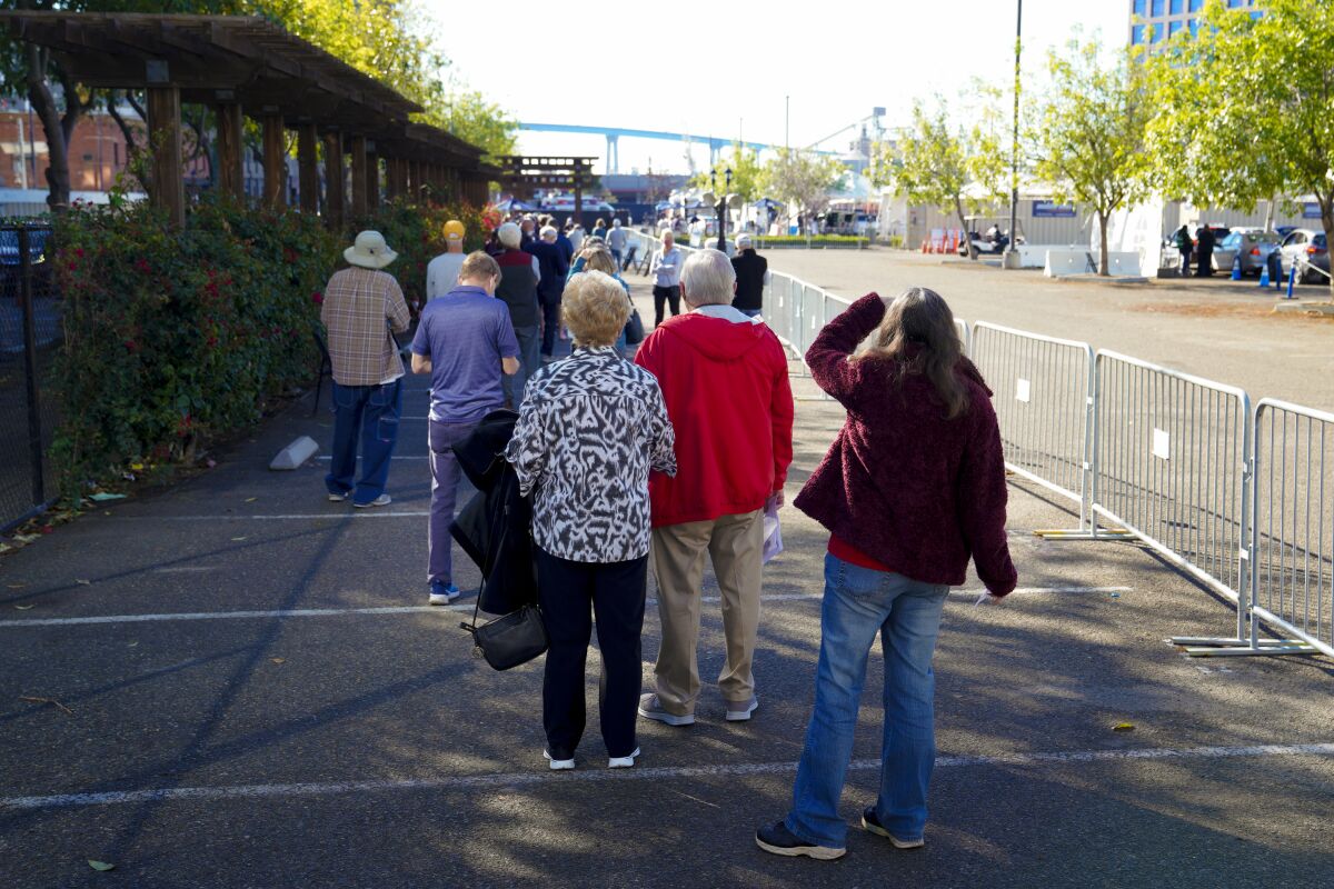 A COVID-19 vaccine line forms downtown at the Petco Park tailgate parking lot. 