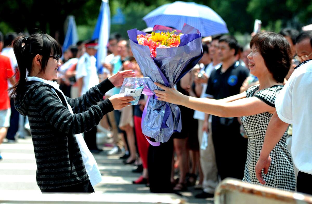 In Beijing, a woman greets her daughter, who finished the first day of China's tough college entrance exam. Students who take the exam in Beijing must have residency permits for the Chinese capital.