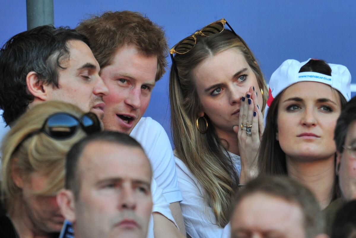 Britain's Prince Harry, second from the left up top, sits next to British socialite Cressida Bonas at a rugby match in March.
