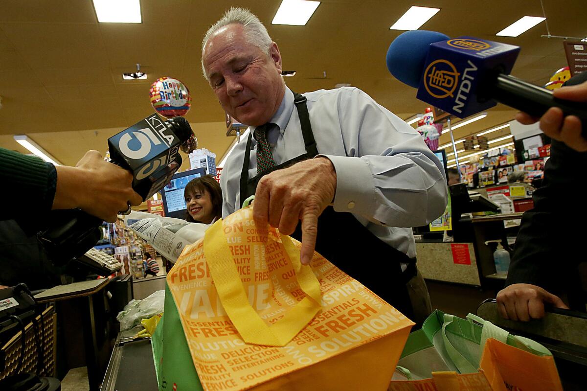 Los Angeles City Councilman Tom LaBonge bags groceries into reusable grocery bags at a Pavilions store in an effort to call attention to an upcoming city ban on plastic bags in the new year.