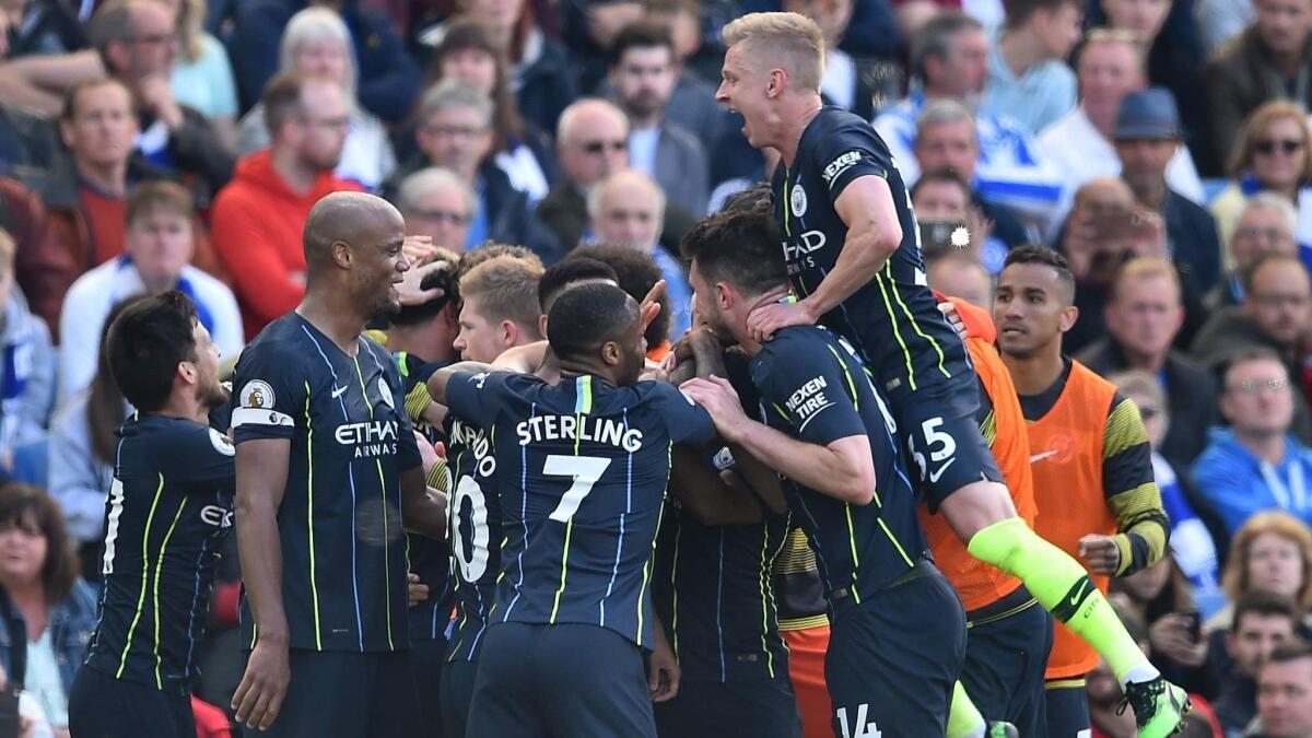 Manchester City players celebrate their third goal against Brighton on May 12.