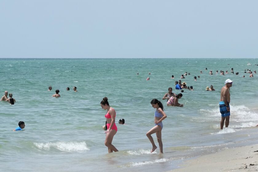 Bañistas se refrescan en aguas del Océano Atlántico, el lunes 10 de julio de 2023, en Hollywood Beach, Florida. (AP Foto/Wilfredo Lee)
