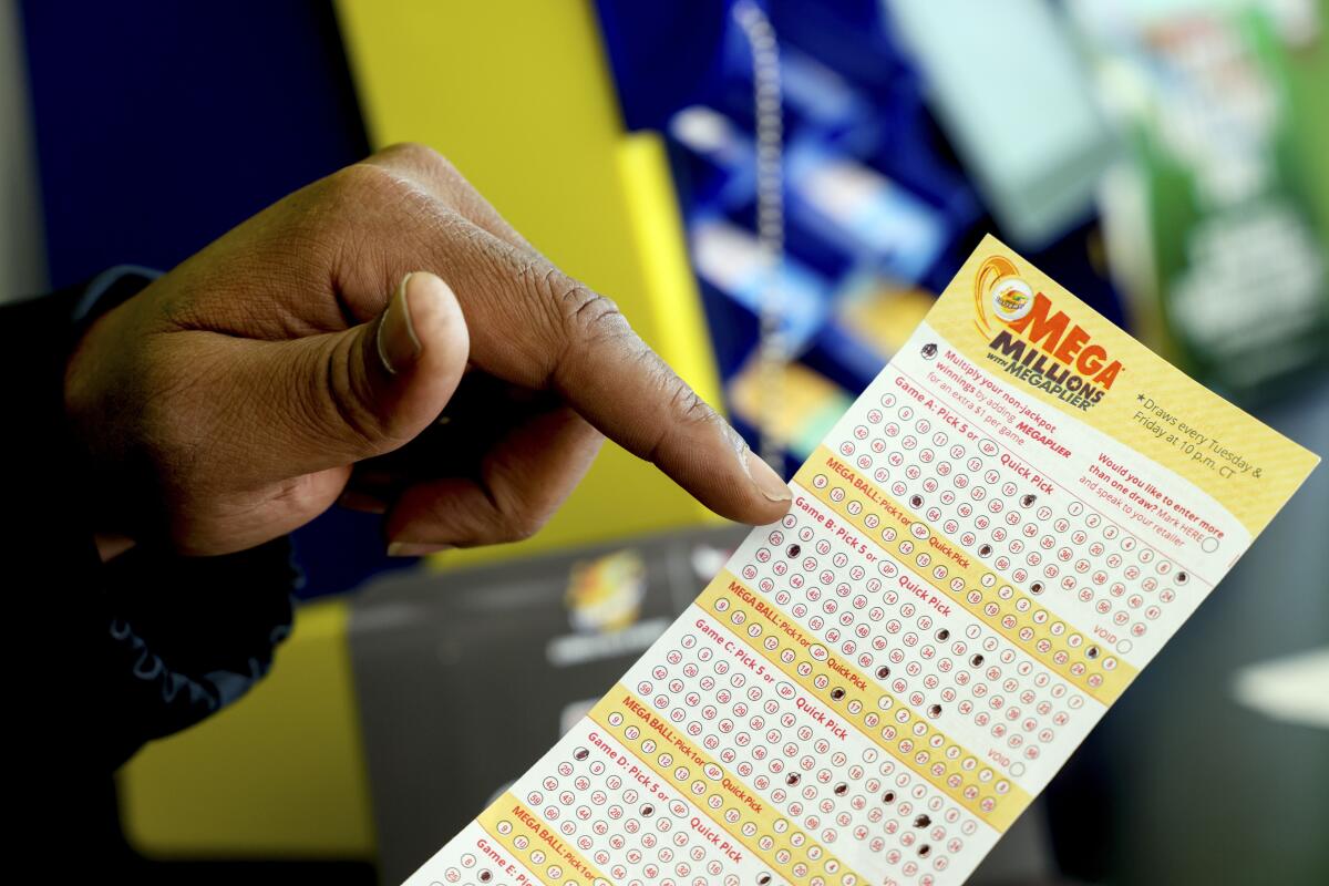 A Mega Millions lottery slip is displayed at Lucky Mart in Chicago on Tuesday, Jan. 10, 2023. After nearly three months of lottery losing, the Mega Millions jackpot has swelled to $1.1 billion. The odds of winning the top lottery prize are formidable at 1 in 302.6 million. (AP Photo/Teresa Crawford)