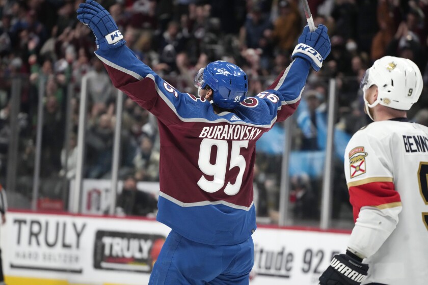 Colorado Avalanche left wing Andre Burakovsky, left, turns and celebrates after netting a goal for his first career hat trick as Florida Panthers center Sam Bennett looks on in the third period of an NHL hockey game Sunday, Dec. 12, 2021, in Denver. Colorado won 3-2. (AP Photo/David Zalubowski)