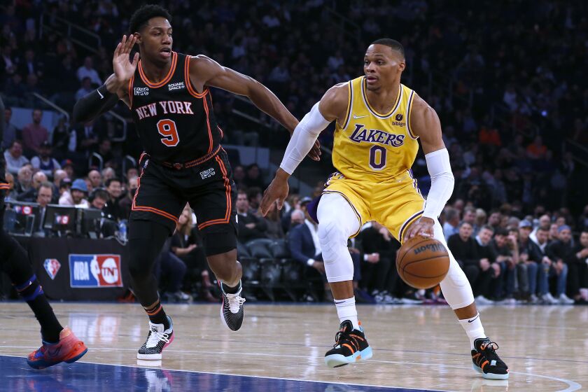 Los Angeles Lakers guard Russell Westbrook (0) drives against New York Knicks guard RJ Barrett (9) during the first half of an NBA basketball game Tuesday, Nov. 23, 2021, in New York. (AP Photo/Jim McIsaac)