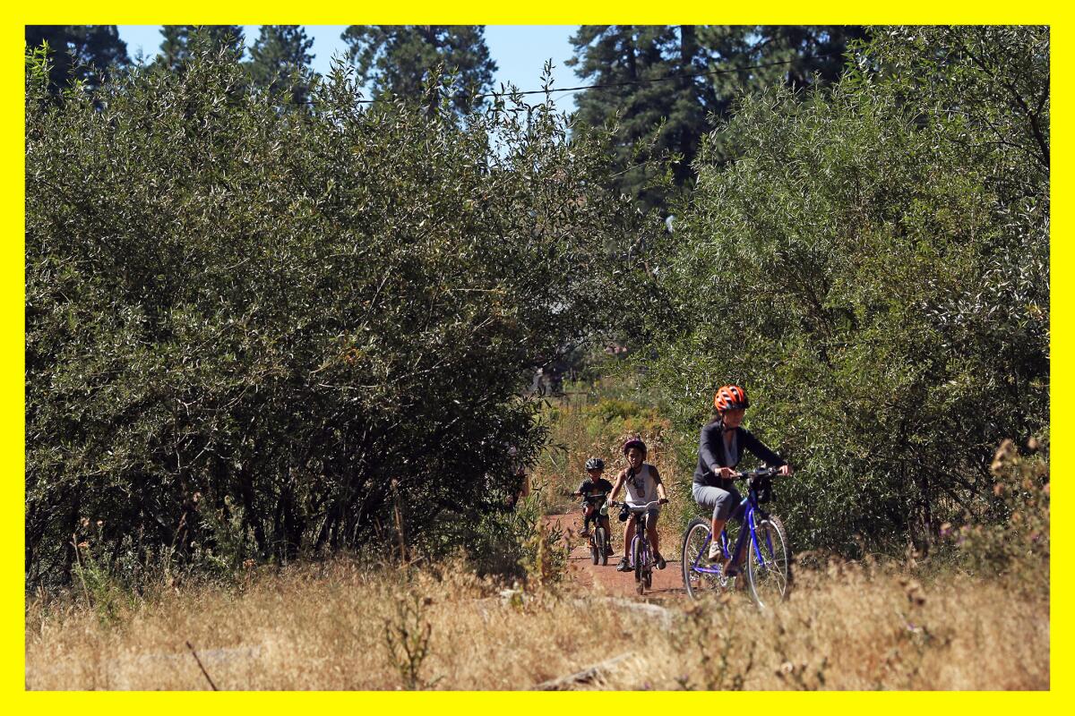 A family rides their bikes through SkyPark at Santa's Village in Skyforest in San Bernardino.