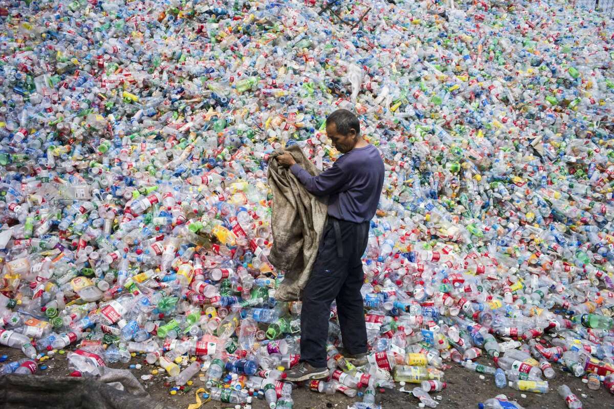 A Chinese laborer sorts plastic bottles for recycling in Dong Xiao Kou village near Beijing on Sept. 17, 2015. China is the world's biggest emitter of greenhouse gases that cause climate change, and a crucial player in the global gathering outside Paris.
