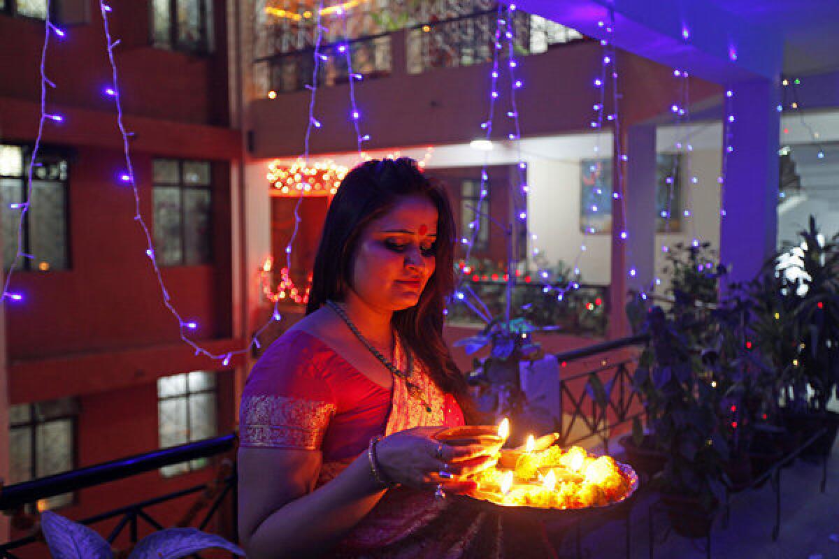 A woman holds a tray filled with earthen lamps during Diwali celebrations in Allahabad, India.
