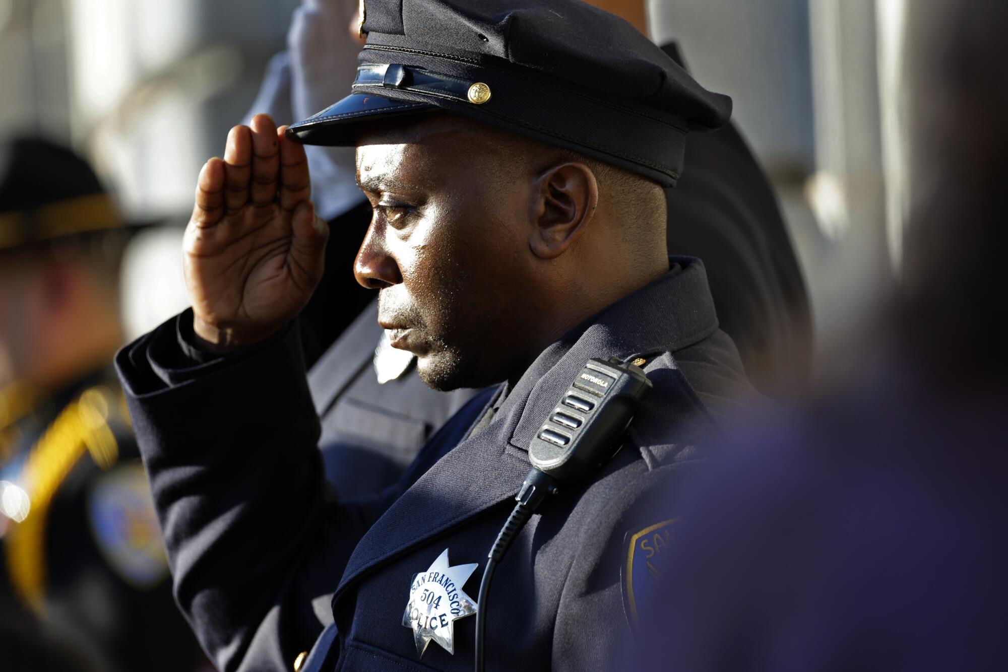 A San Francisco police office salutes as the casket of the late Sen. Dianne Feinstein