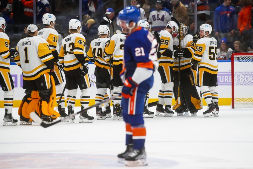 Pittsburgh Penguins' players celebrates after defeating the New York Islanders during an NHL hockey game, Friday, Nov. 26, 2021, in Elmont, N.Y. (AP Photo/Eduardo Munoz Alvarez)