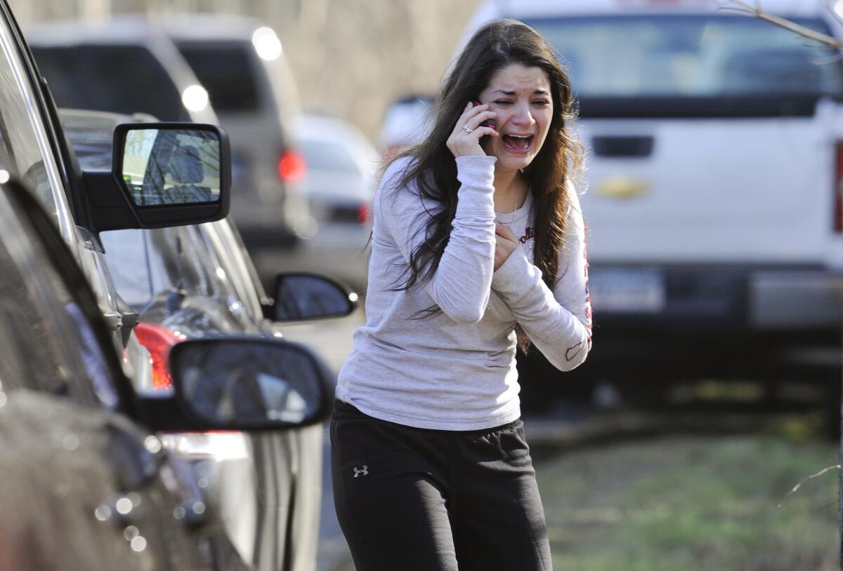 FILE - Carlee Soto uses a phone to get information about her sister, Victoria Soto, a teacher at the Sandy Hook elementary school in Newtown, Conn., after a gunman killed over two dozen people, including 20 children, on Dec. 14, 2012. An FBI agent struggled to control his emotions Tuesday, Sept. 13, 2022, as he described on the witness stand seeing bodies inside Sandy Hook elementary school — a scene that the conspiracy theorist Alex Jones later claimed was staged by actors. (AP Photo/Jessica Hill, File)