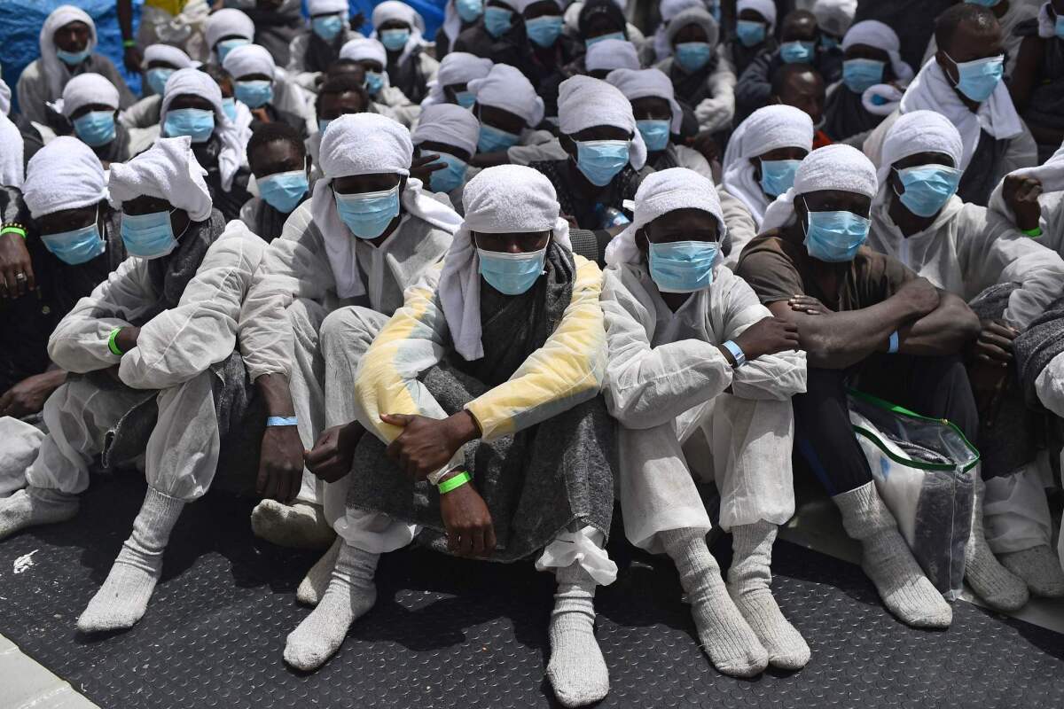 Migrants plucked from the Mediterranean Sea wait aboard a ship operated by the aid groups SOS Mediterranee and Doctors Without Borders on May 26.