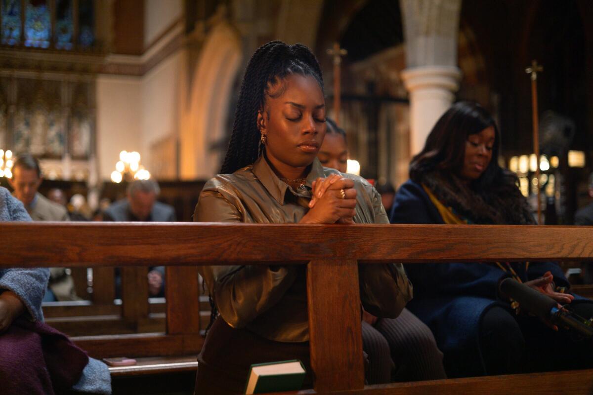 A woman praying in a church pew.