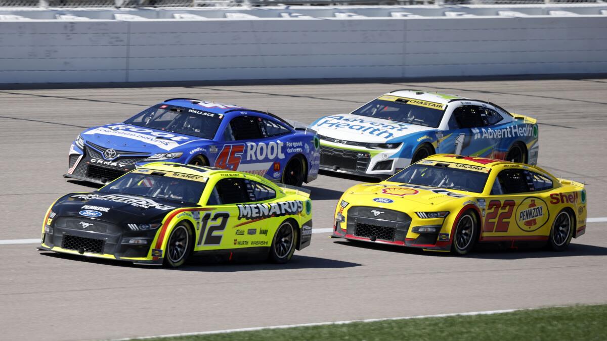 Bubba Wallace (45), Ryan Blaney (12), Ross Chastain (1) and Joey Logano (22) head toward Turn 1 during a NASCAR Cup Series auto race at Kansas Speedway in Kansas City, Kan., Sunday, Sept. 11, 2022. (AP Photo/Colin E. Braley)