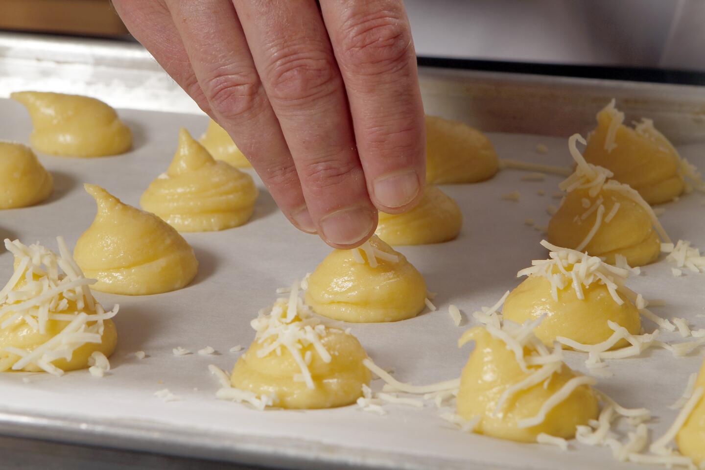 Sprinkle the gougeres with cheese.