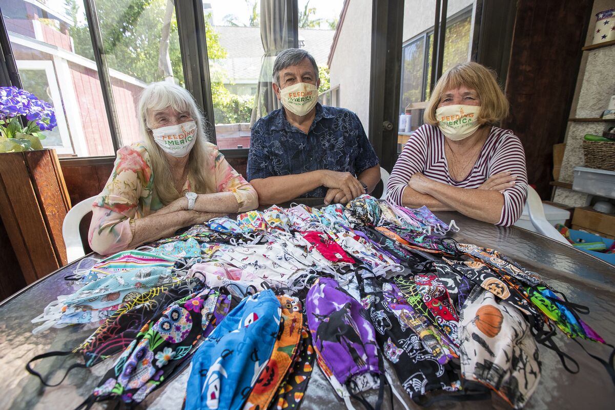 Peggy Engard, left, and her husband, Ted, center, and friend Kathy Gordon have been making masks since the pandemic started.