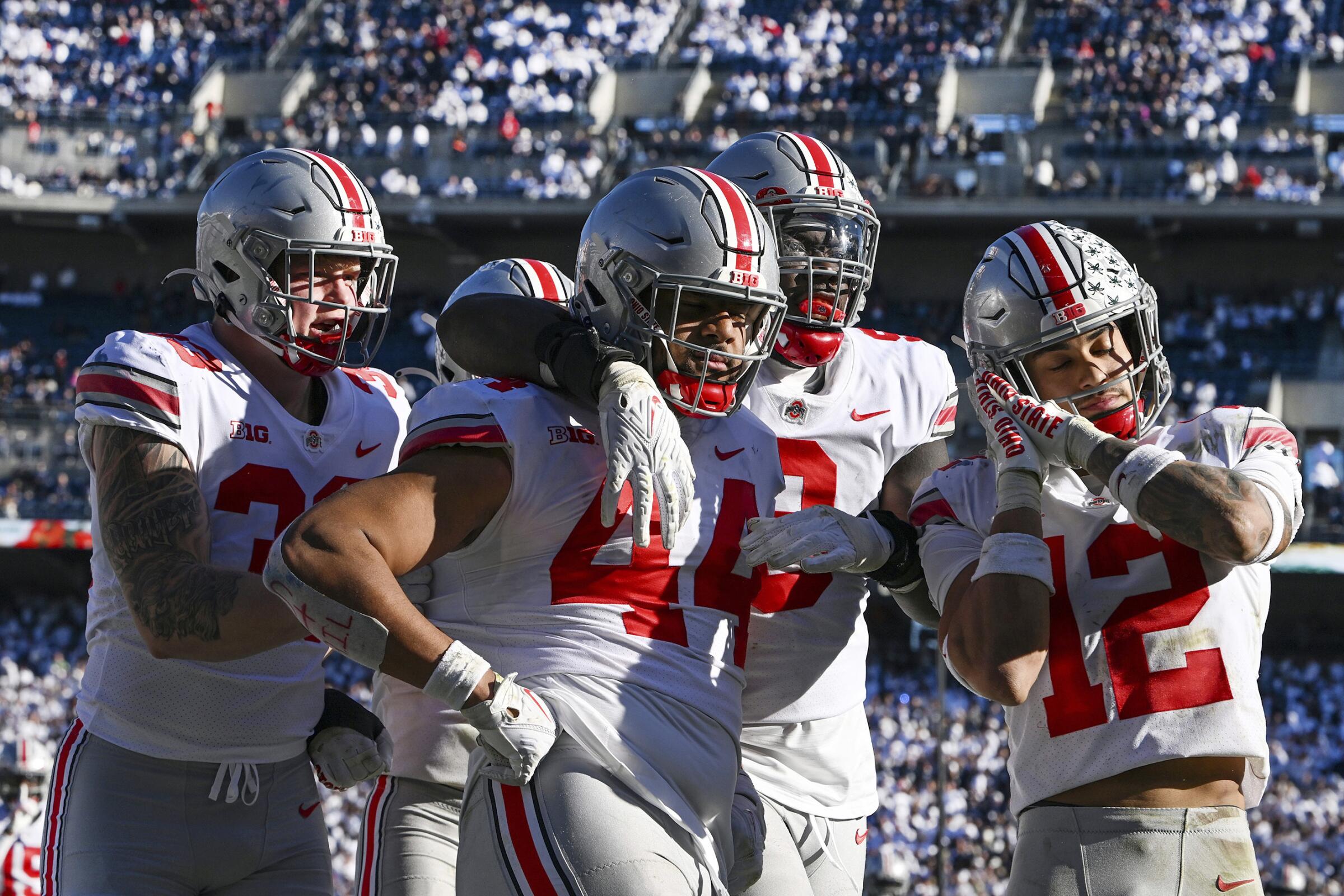 Ohio State defensive end J.T. Tuimoloau celebrates with his teammates after returning an interception for a touchdown.
