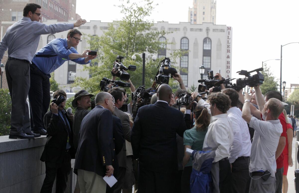 Journalists surround former Virginia Gov. Bob McDonnell, obscured, after a day in court in Richmond, Va., where he and his wife, Maureen, are on trial.