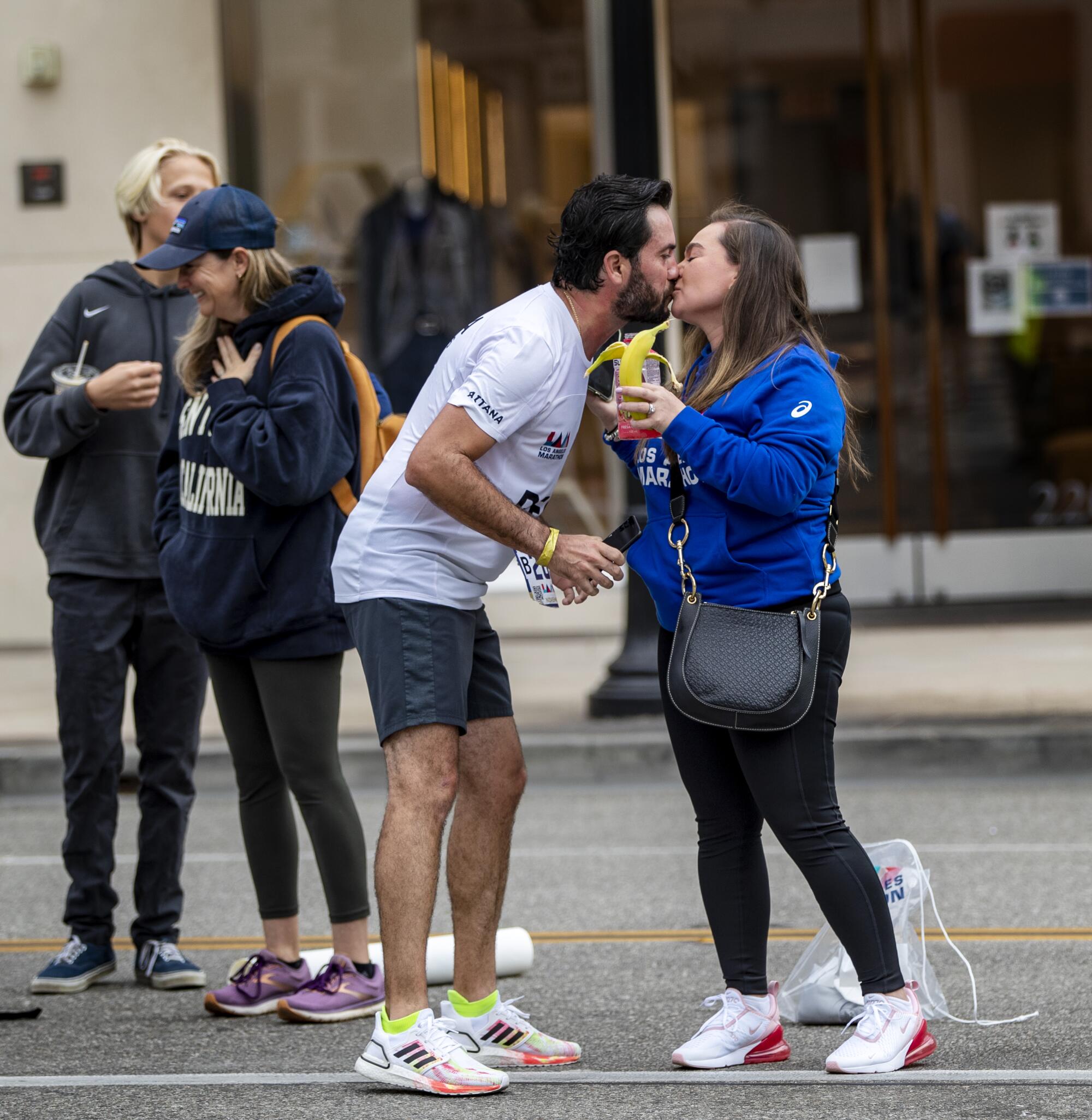 Runner Edsel Perez of Mexico City gets a kiss and a banana from his wife.