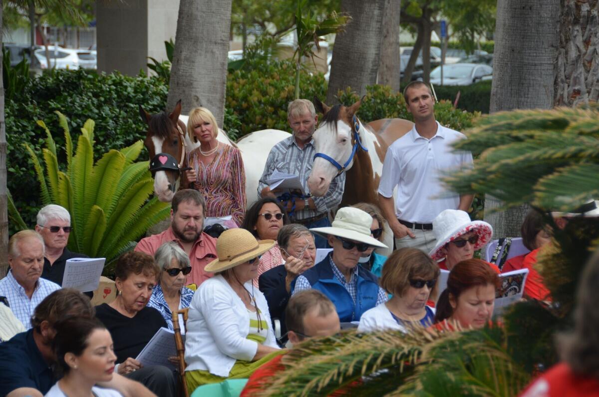 Parishioners, some with their animals, attend Sunday services at a park near St. James church on Lido Isle in July.