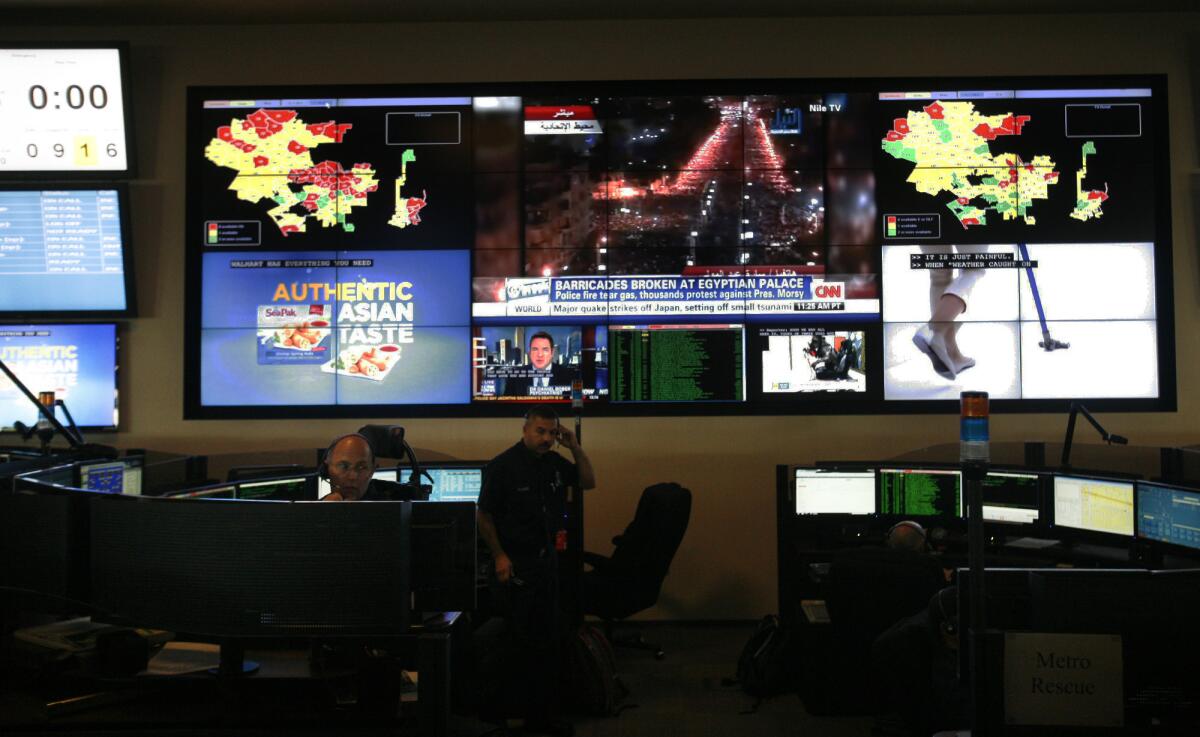 Electronic maps of the city and television station broadcasts play on the wall at the Los Angeles Fire Department Dispatch Center.