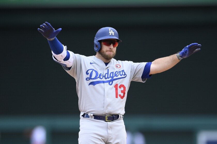 Max Muncy, in batting helmet, stretches his arms out.