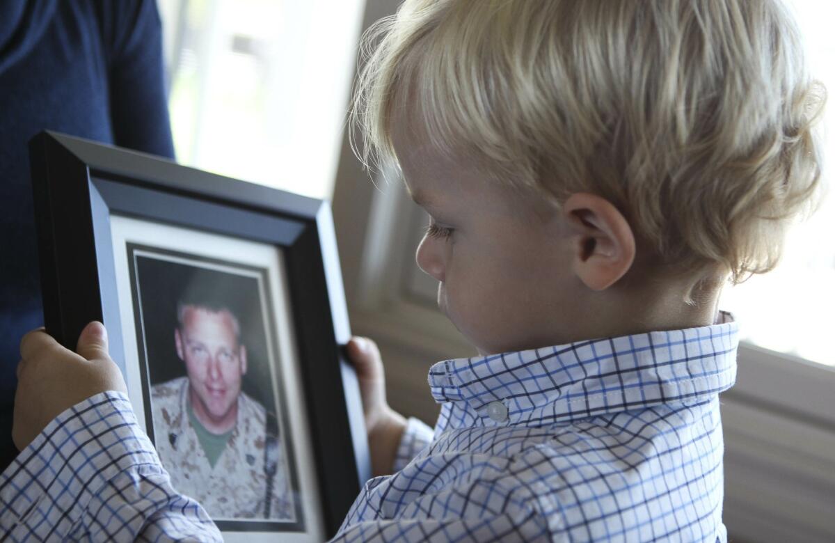 Nathan Murzyn, 2, looks at a picture of his father Marine veteran Russell Murzyn, who died by suicide.