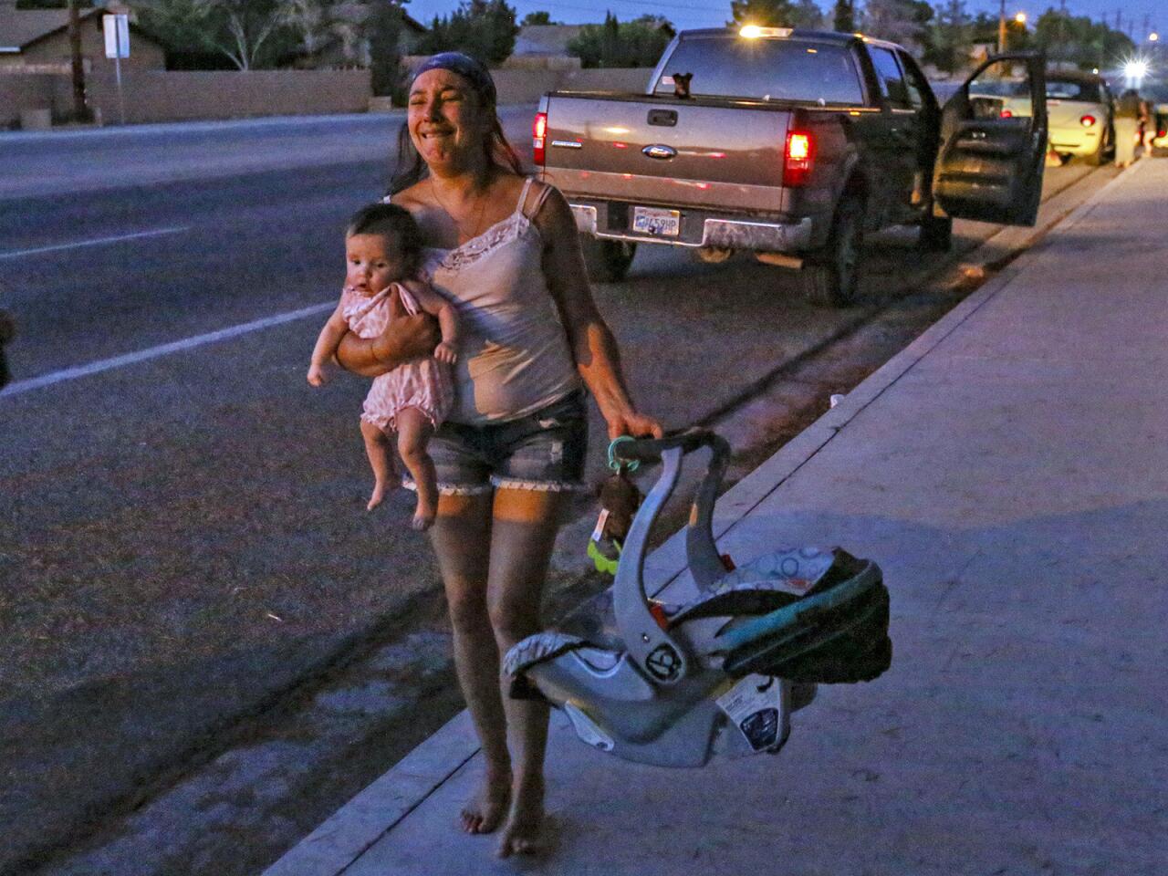 Dawn Inscore leaves her apartment on Ridgecrest Boulevard with her child after the Friday night earthquake.