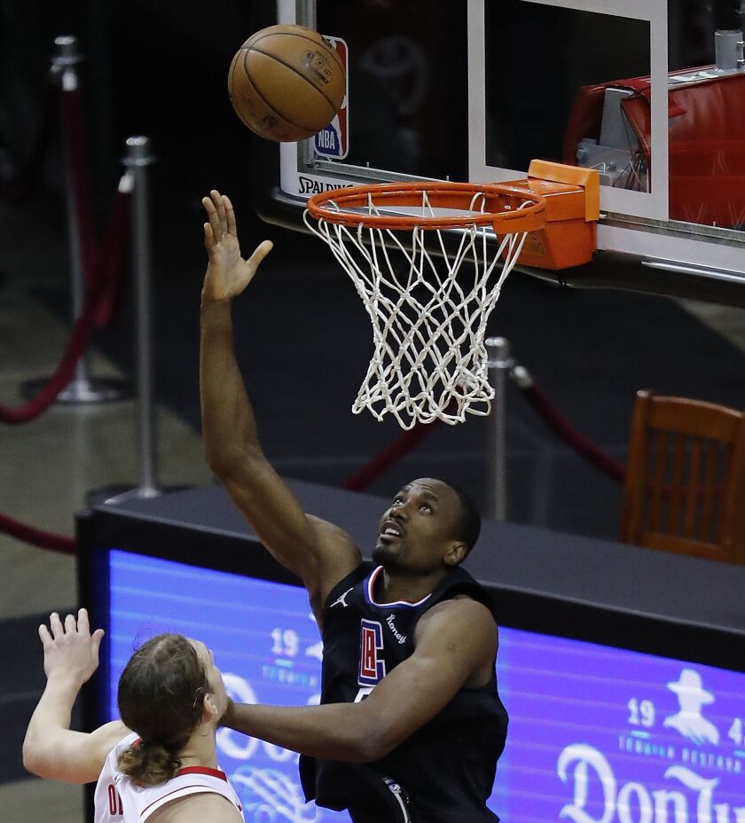 The Clippers' Serge Ibaka shoots a layup over the Rockets' Kelly Olynyk on May 14, 2021.