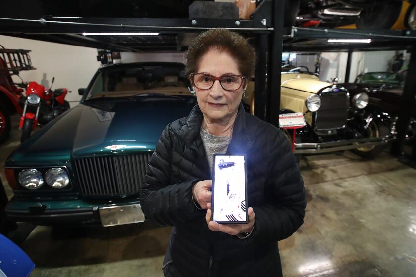 Iris McCray holds a picture of her husband, a lifelong. Military man who served in three wars during a tour of the Marconi Automotive Museum with the LIFT group in Tustin. LIFT is a social group for widows and widowers to build friendships, learn new skills, and stay active, after the loss of a loved one.